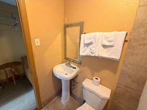 Un baño con lavamanos, inodoro y espejo.