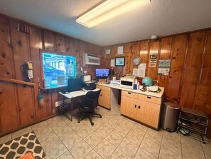 A home office with a desk, computer, and various office supplies.