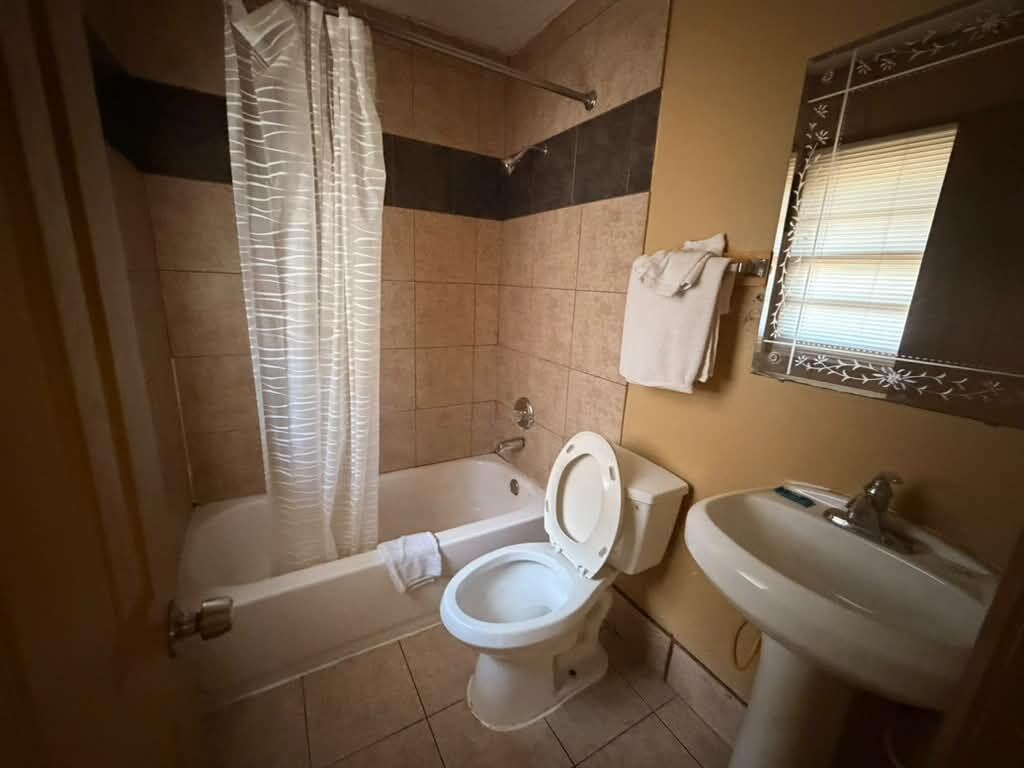 Et badeværelse med badekar, toilet og håndvask.