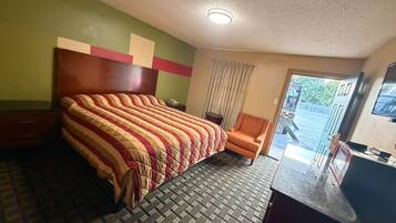 Habitación de hotel con una cama, una silla, un escritorio y una ventana.