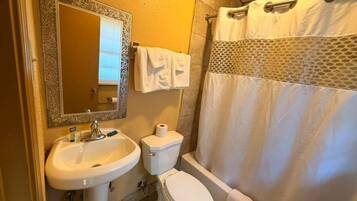 Een badkamer met een wastafel, toilet en bad.