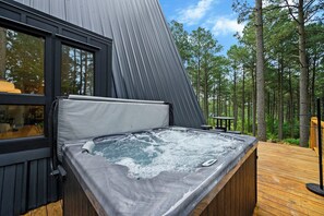A hot tub on a wooden deck with a view of a forest. - Pine + Peak • Luxury A-Frame • Adventure Zone • Hot Tub (Broken Bow)