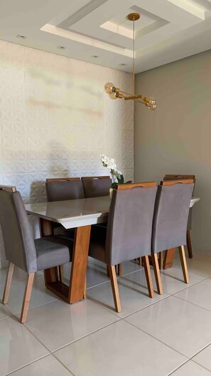 A dining area with a rectangular table, six chairs, and a hanging light fixture. - Complete, spacious, modern and cozy house. (Leopoldina)