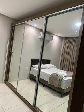 A modern bedroom with a glass partition, a bed, a bedside table, and an air conditioning unit. - Complete, spacious, modern and cozy house. (Leopoldina)