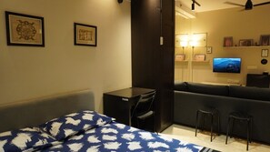 Ein Hotelzimmer mit einem Bett, einem Schreibtisch, einer Couch und einem Fernseher.