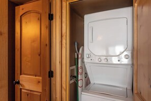 Ein Waschraum mit einer Holztür und einer weißen Waschmaschine.