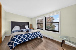 Ein Schlafzimmer mit einem Bett, einem Fenster mit Blick und einem Glastisch.
