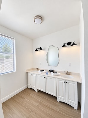 A bathroom with a double sink, a large mirror, and two wall-mounted lights. - Newly Listed -Canal front 2-bedroom Villa (Providenciales)