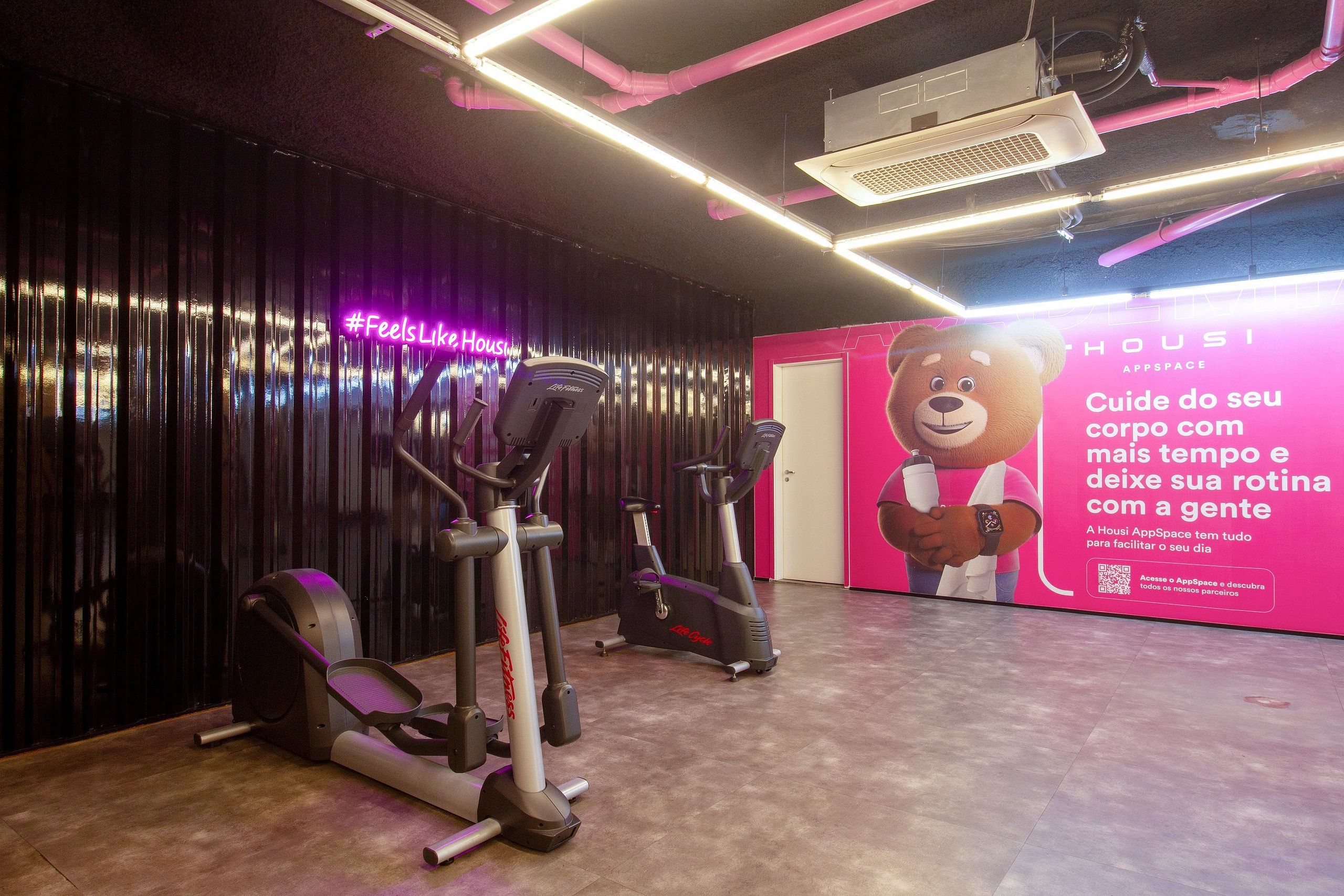 Un gimnasio con equipo de ejercicio y un gran anuncio en la pared.