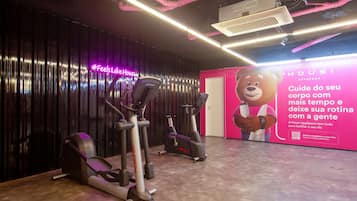Un gimnasio con equipo de ejercicio y un gran anuncio en la pared.