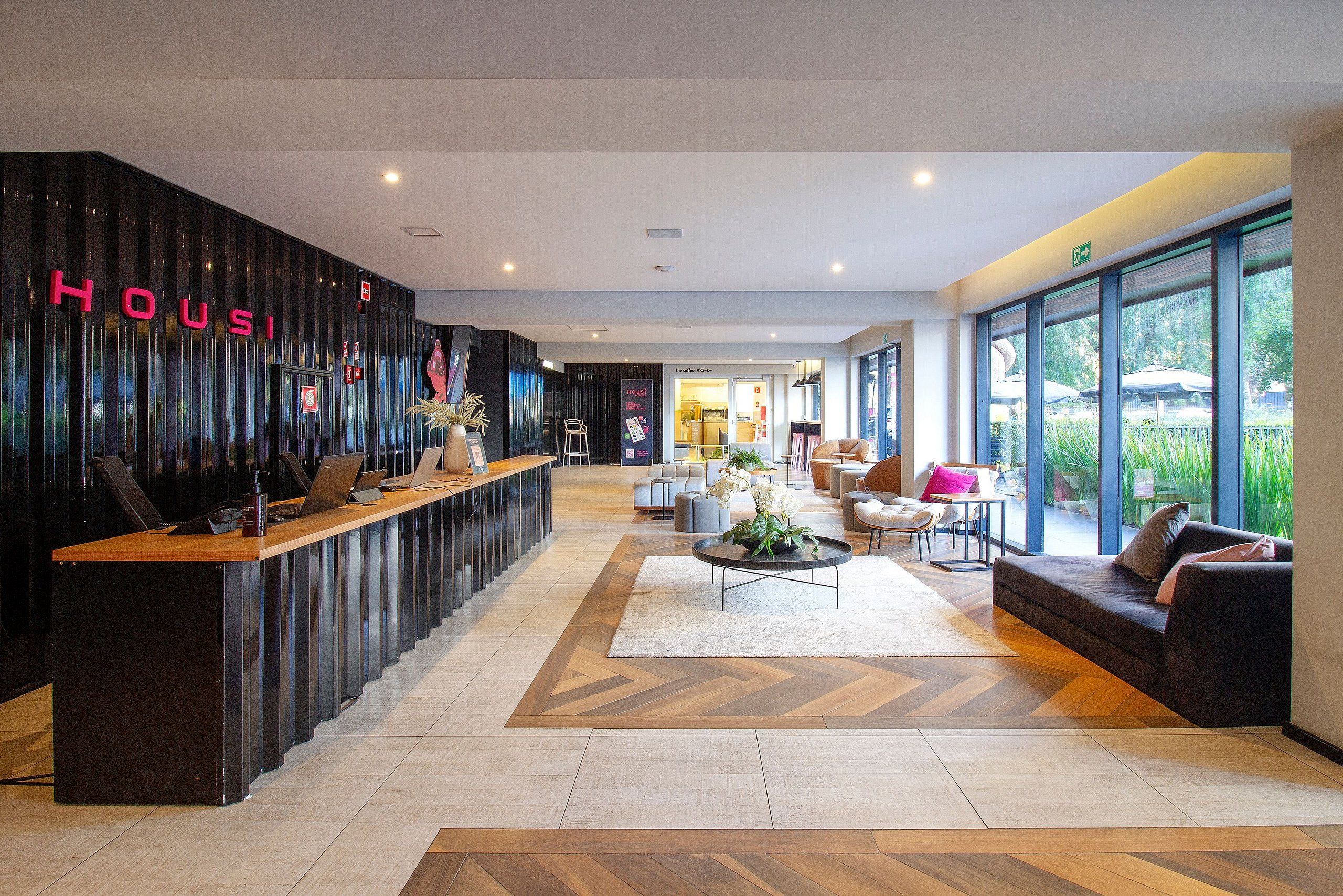 Un hall d’hôtel moderne doté d’un comptoir d’accueil, d’un espace salon et de grandes fenêtres offrant une vue panoramique.