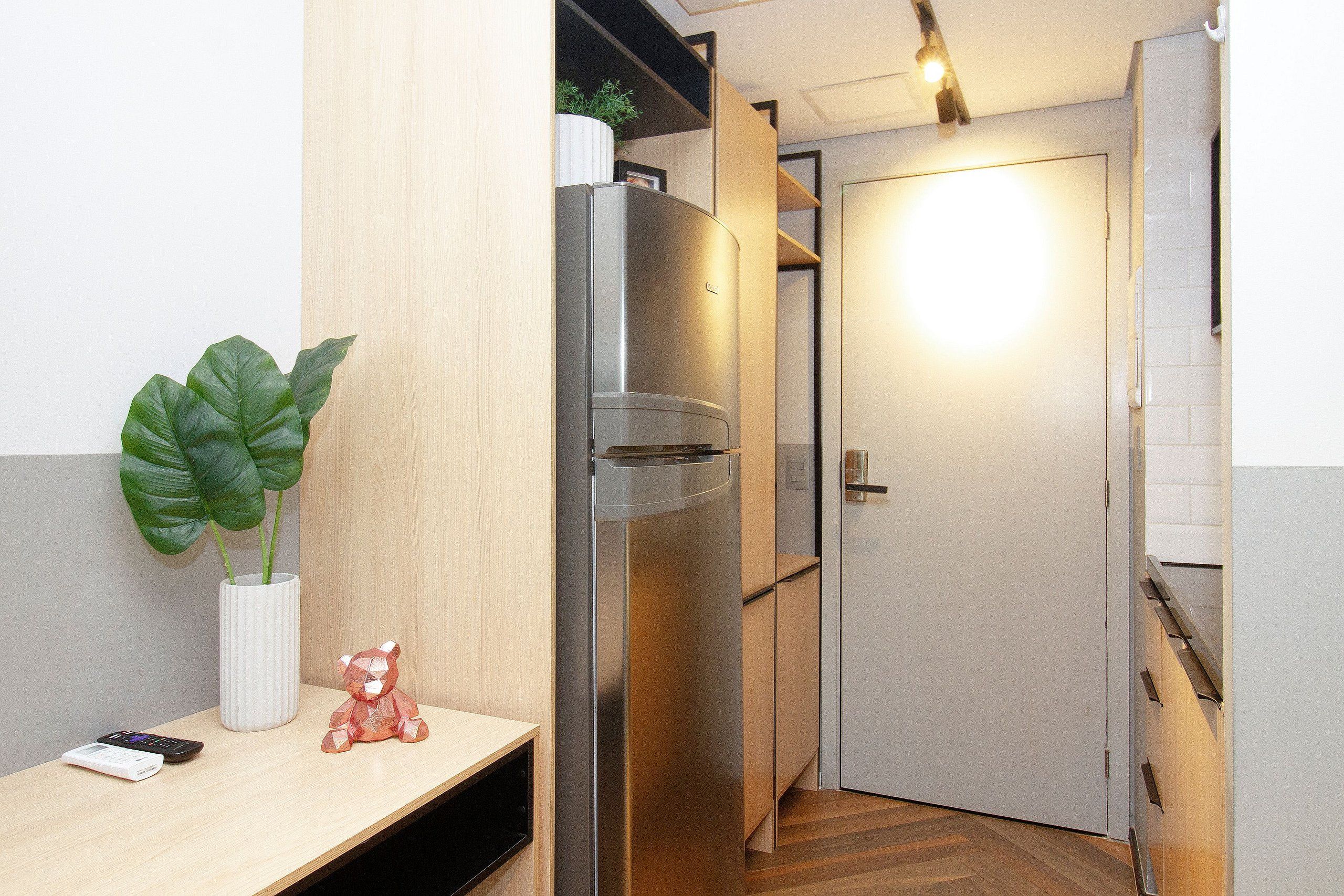 A modern kitchen with a built-in refrigerator, a wooden countertop, a potted plant, and a small decorative item.