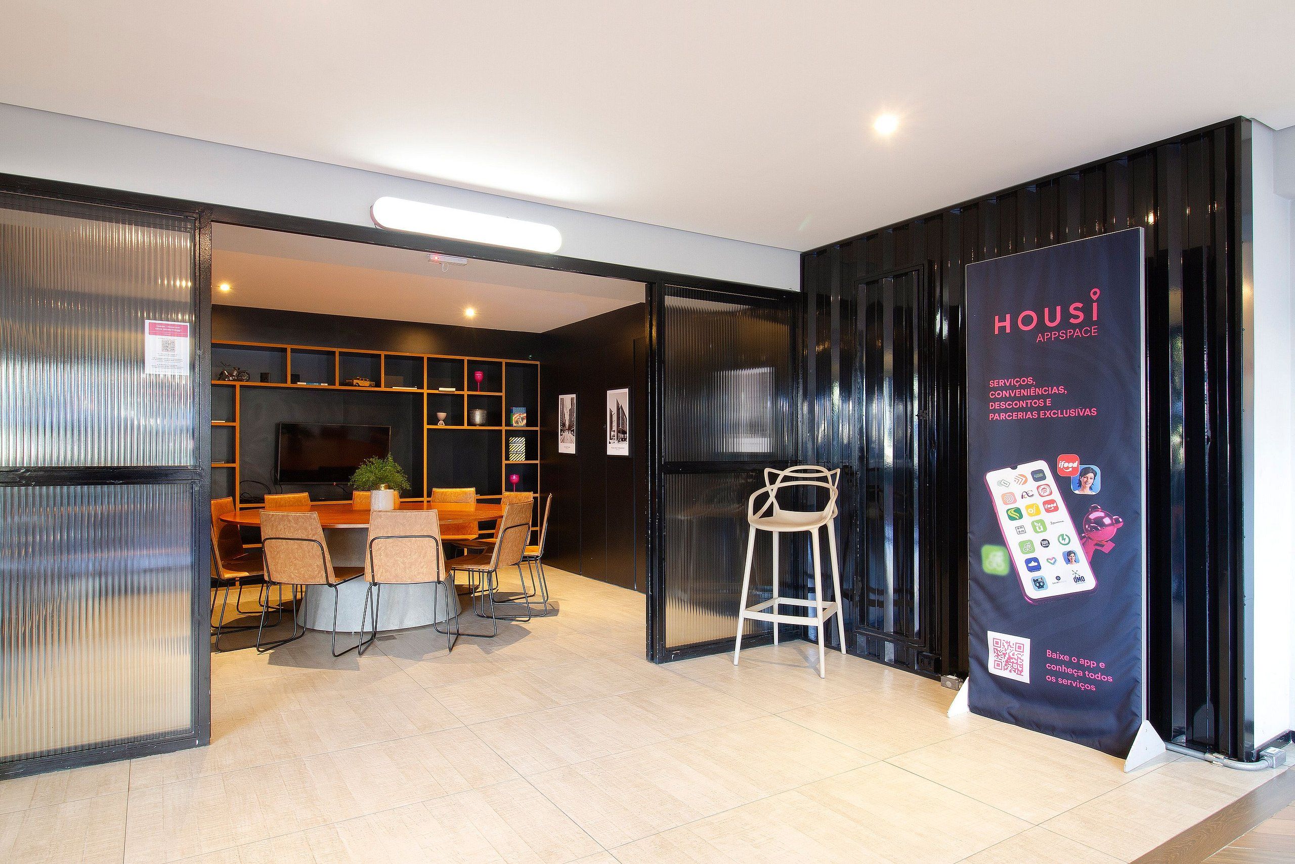 Un intérieur moderne comprenant un comptoir d’accueil, un espace détente et une grande affiche publicitaire présentant les services proposés.