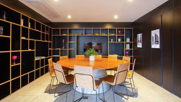 Un espace repas moderne avec une table ronde et des chaises, entouré d’étagères et d’objets décoratifs.