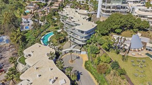 An aerial view of a residential area with modern houses, a swimming pool, and lush greenery. - Panoramic View by IIM (Benalmádena)