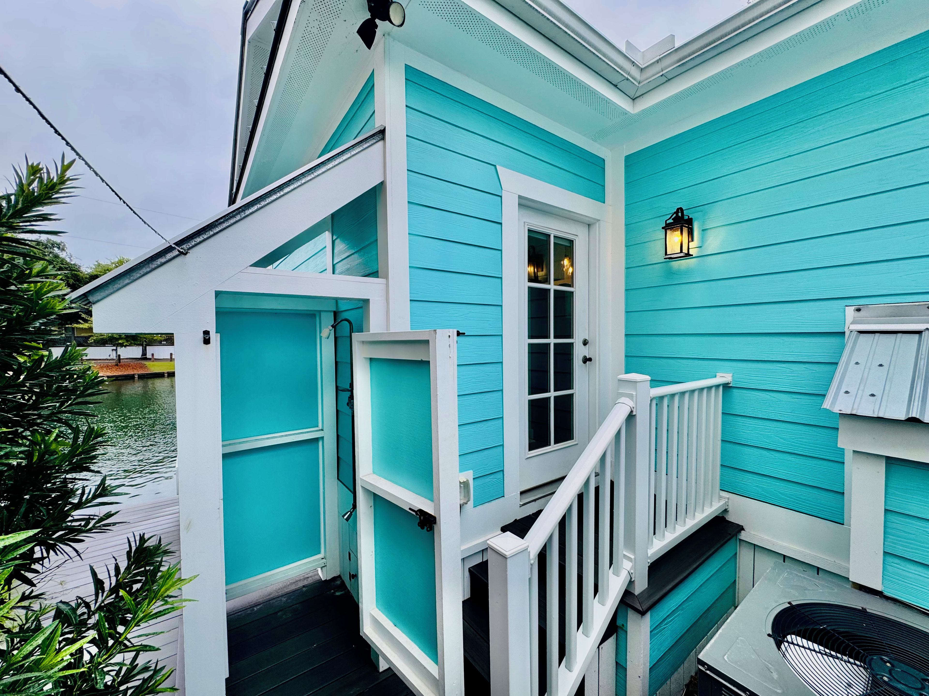 A turquoise building with a white door and a small porch.