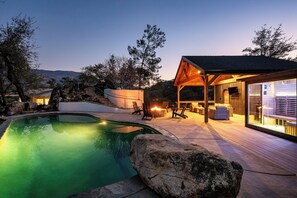 A pool with a wooden deck and lounge chairs, a covered patio area with seating, and a view of the surrounding landscape. - Upscale Sequoia Retreat - Hot Tub, Sauna, & Pool (Three Rivers)