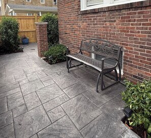 A paved patio area with a metal bench and potted plants. - Luxury 2BR-1BA- Broadway BNB- Walk to Centre (Danville)