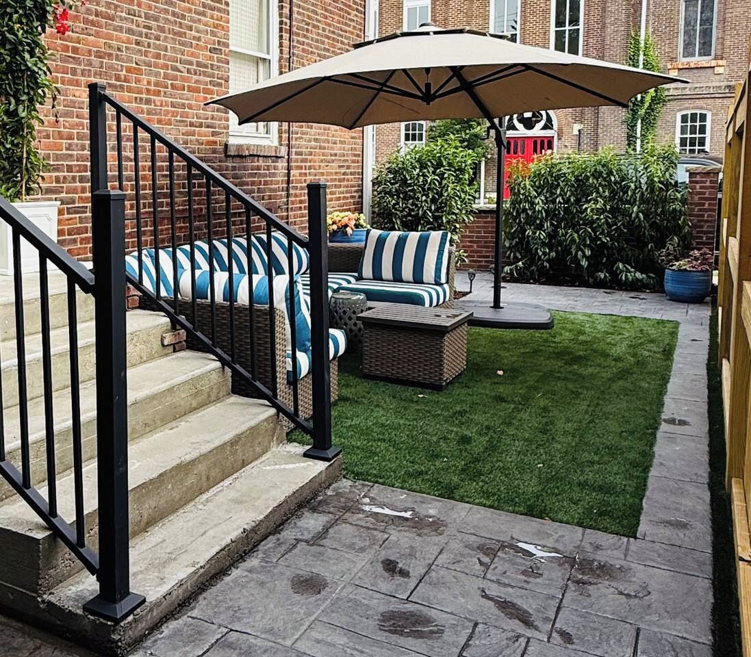 A patio area with a staircase, outdoor seating, and a lawn.