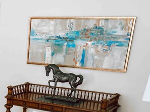 A room with a painting on the wall, a wooden bench, and a horse sculpture. - Broadway BNBs I - 1 BR Apartment - Walk to Centre (Danville)