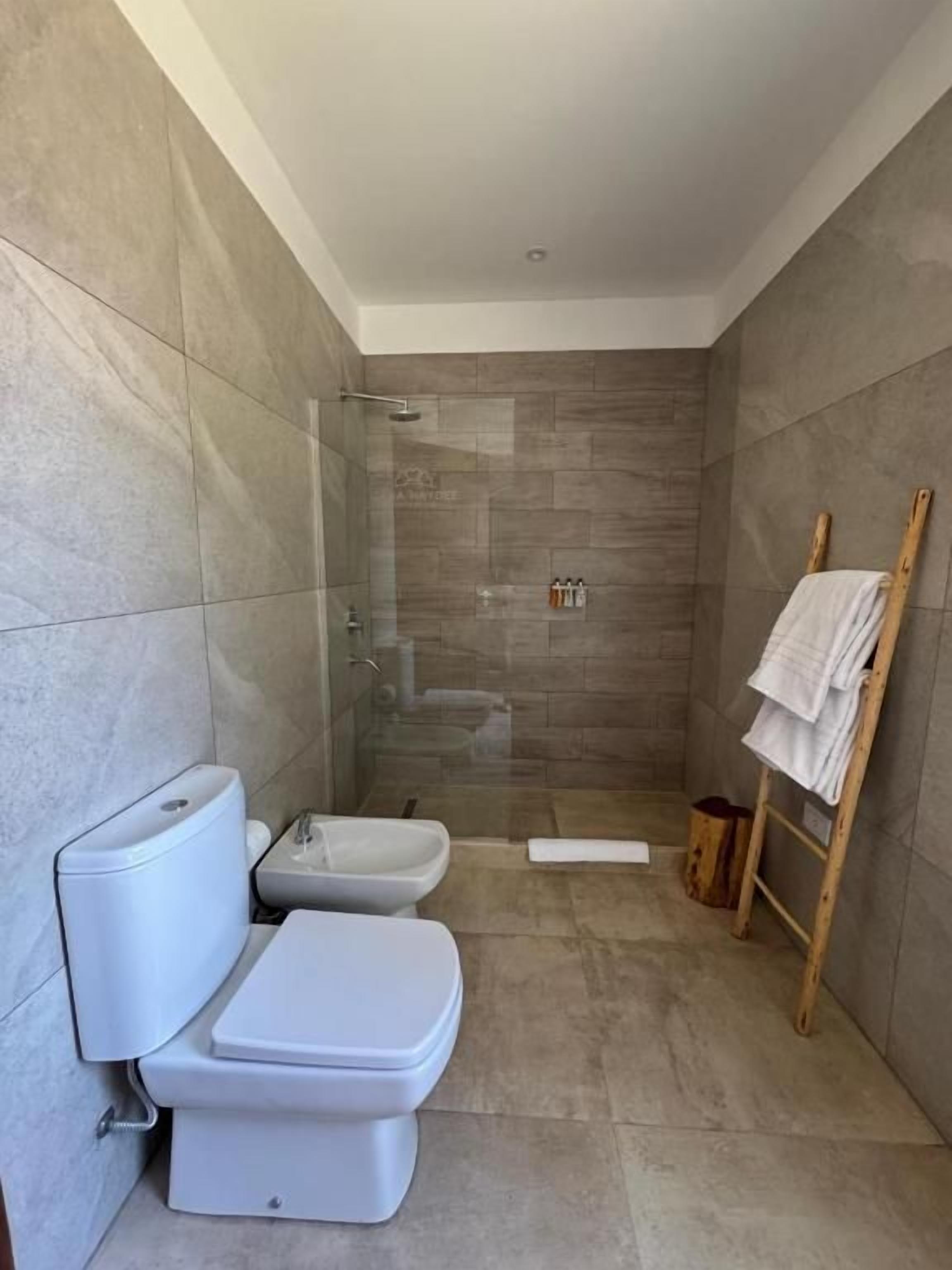 Un baño moderno con ducha acristalada, inodoro y bidé.