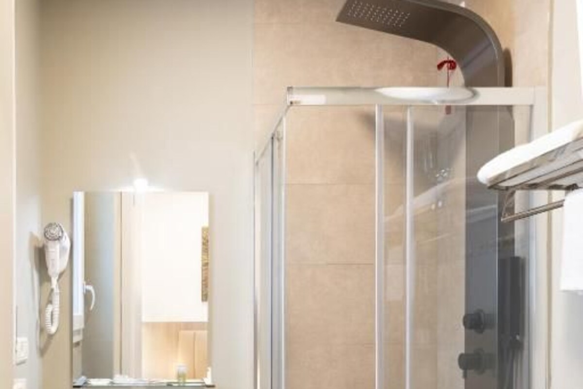 Een badkamer met een douchecabine, een wastafel en een toilet.