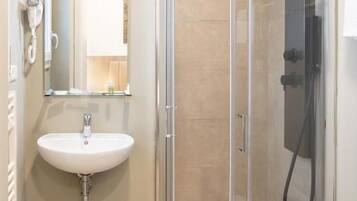 Een badkamer met een douchecabine, een wastafel en een toilet.