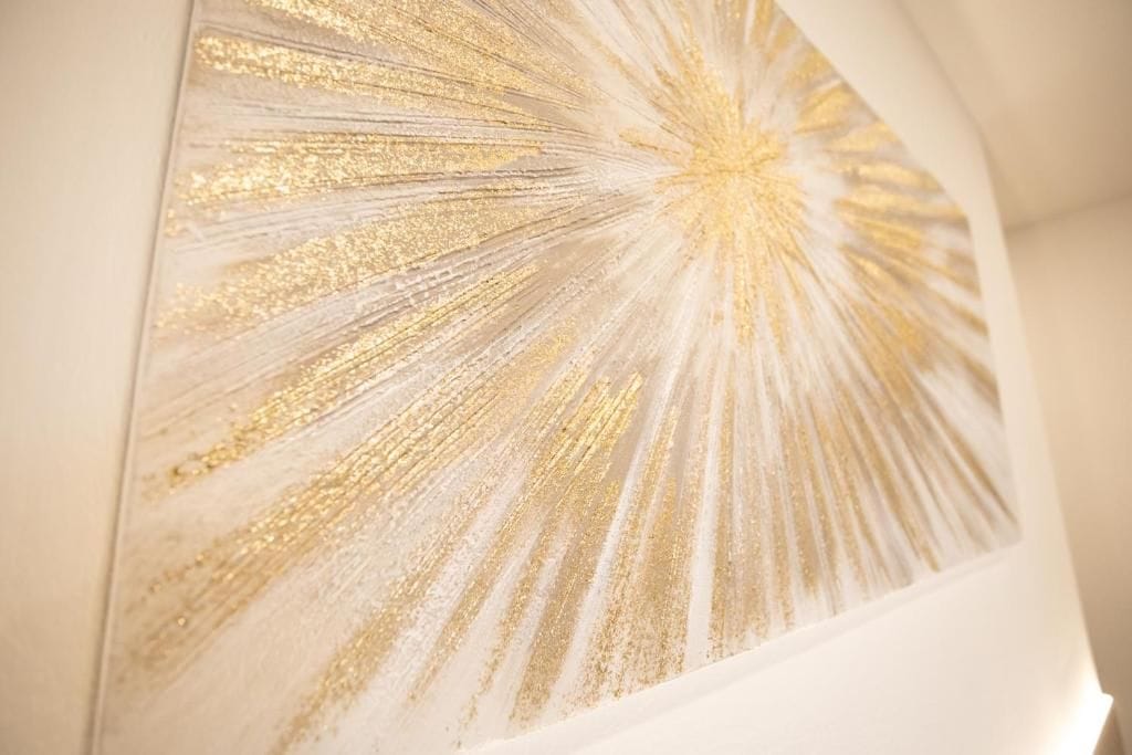 Una pared con un patrón dorado y radiante.