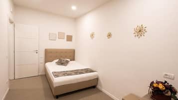 A bedroom with a bed, a door, and wall decorations.