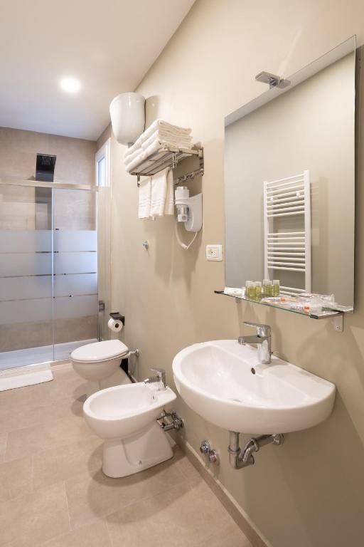 Un baño con lavamanos doble, inodoro y bidé.