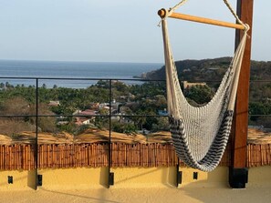Una hamaca en un balcón con vistas a un pueblo costero.