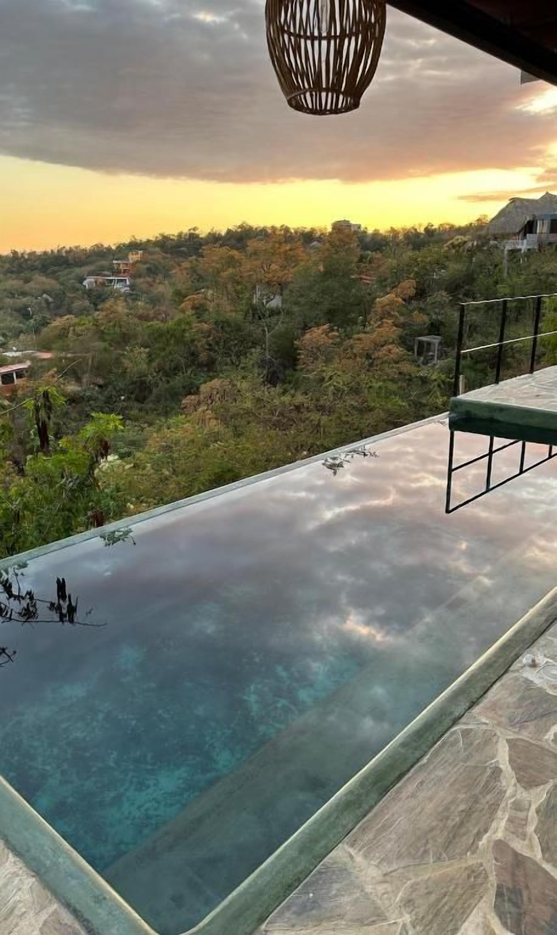 Una piscina infinita con vistas despejadas a un paisaje boscoso.
