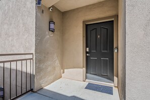 A building entrance with a black door, a mailbox, and a small outdoor light fixture. - Home Sweet Stay 2BD/2BA • Pool • Gym (Scottsdale)