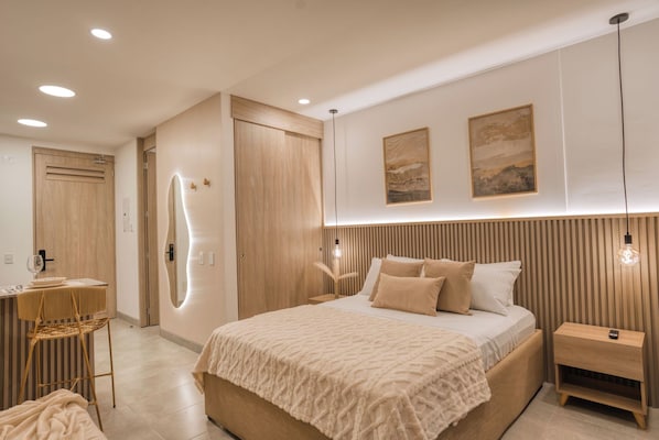 Un dormitorio moderno con una cama grande, mesitas de noche, un espejo y obras de arte en la pared.