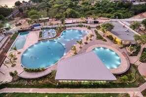 An aerial view of a resort with multiple swimming pools, landscaped areas, and a parking lot. - Skyline Beach Resort 2003 (Santa Marta)