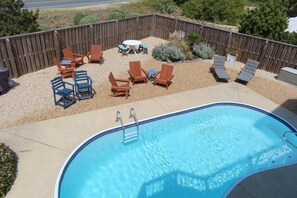 A backyard with a swimming pool, wooden deck, and outdoor furniture. - Walk to Beach w Pool, GameRm, Summer Availability! (Corolla)