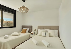 A hotel room with two beds, a window, and a hanging light fixture. - Skyline Penthouse by IIM (Fuengirola)