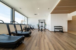 A gym with treadmills, stationary bikes, a weight bench, and a rack of dumbbells. - Skyline Penthouse by IIM (Fuengirola)