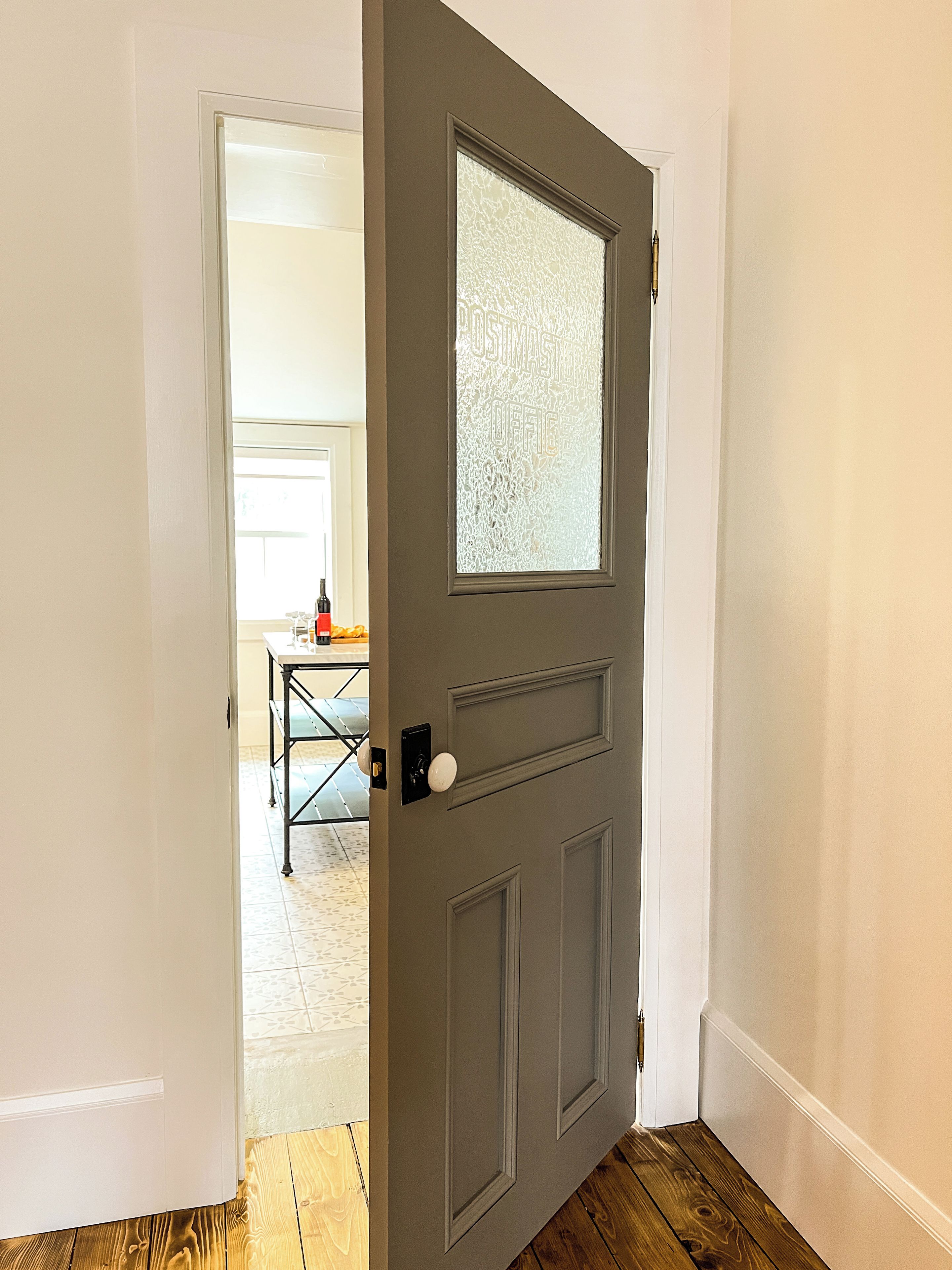A partially open door with a frosted glass panel and a white doorknob.