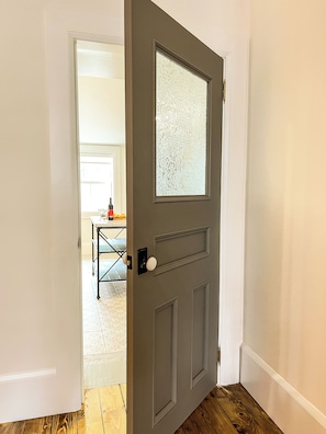 A partially open door with a frosted glass panel and a white doorknob.