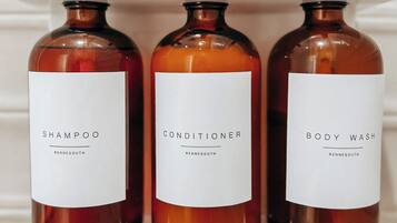 Three bottles of liquid on a shelf.