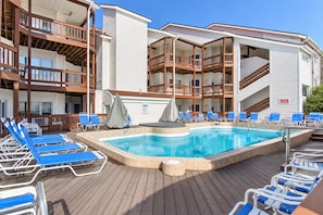 A pool area with lounge chairs and a hot tub. - Bay Breeze 107 | Beachfront Condo | Near Downtown & Tart Trail (Traverse City)
