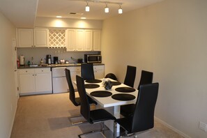 A compact kitchen with white cabinets, a microwave, and a dining table with black chairs. - Albuquerque Foothills Guesthouse near Trails: Pool Table, King Bed, Fast Wi-Fi (Albuquerque)
