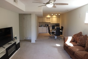 A living room with a television, a sofa, and a ceiling fan. - Albuquerque Foothills Guesthouse near Trails: Pool Table, King Bed, Fast Wi-Fi (Albuquerque)
