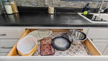 Un comptoir de cuisine avec une machine à café, une tasse et un flacon de savon pour les mains.