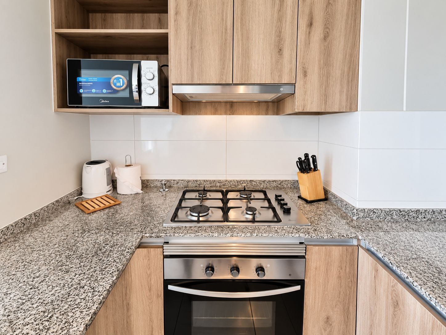 Une cuisine moderne équipée d’un four à micro-ondes encastré, d’une cuisinière à gaz et d’un four traditionnel.