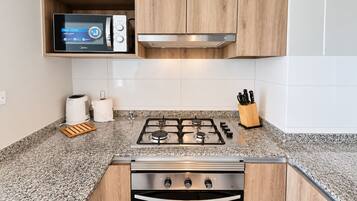 Una cocina moderna con microondas integrado, cocina a gas y horno.