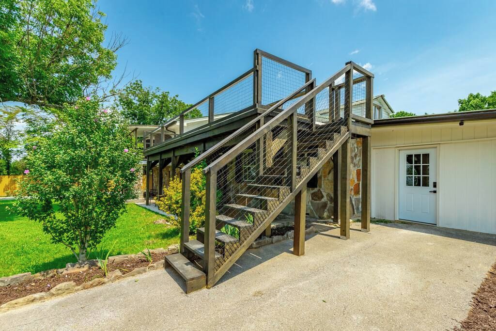A residential property with a two-story staircase, a garage, and a well-maintained lawn.