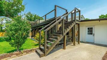 A residential property with a two-story staircase, a garage, and a well-maintained lawn.
