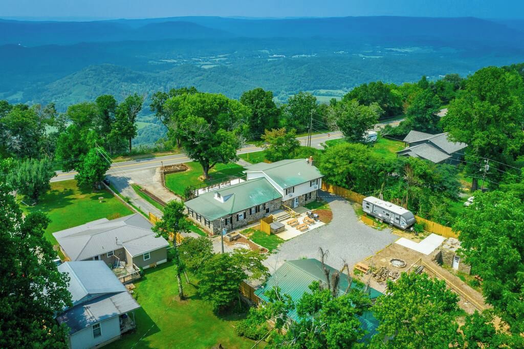 A residential area with multiple houses, a central building with a green roof, and a clear view of the surrounding landscape.